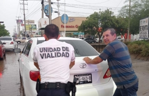 Conductor de un autom&oacute;vil queda estancado en canal de aguas pluviales